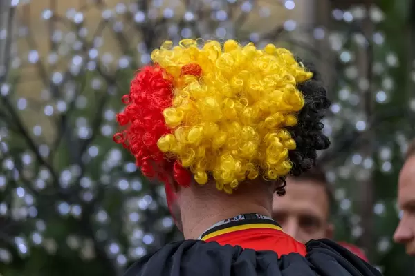 Belgischer Fußballfan mit Perücke in Schwarz, Gelb und Rot