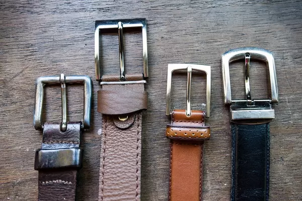 Belt buckles in a close up shot on a wooden table