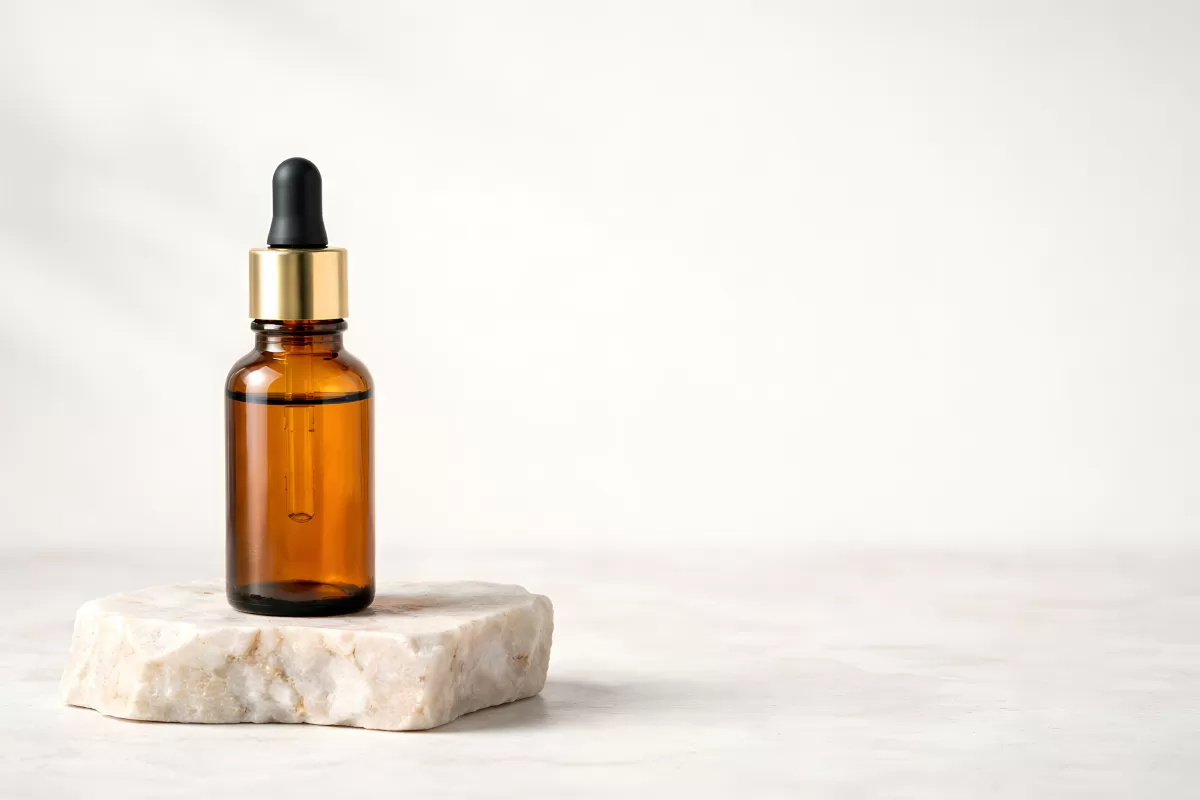 Bernsteinfarbiges Glasfläschchen auf Marmorsockel