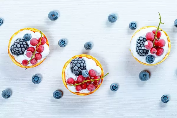 Berry cakes on a white wooden background. Top view (Flip 2019)