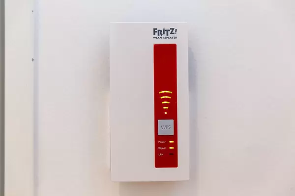 Besserer Internetempfang durch den AVM FRITZ!WLAN Repeater 1750E in rot und weiß, mit Steckdosenanschluss, in der Nahaufnahme