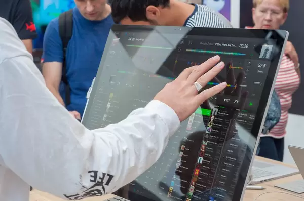 Besucher bedient einen Microsoft Surface Studio per Touchscreen