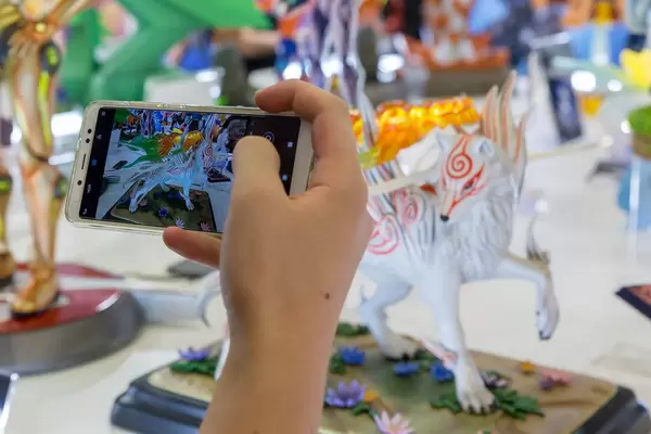 Besucher fotografiert Sammelfigur von Shiranui aus Okami mit seinem Handy