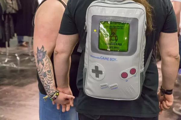 Besucher mit Rucksack in Form eines Nintendo Game Boys