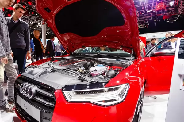 Besucher schauen sich den Motor von dem Audi Modell S6 an