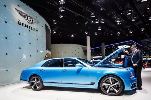 Besucher schaut sich das Modell Flying Spur von Bentley an