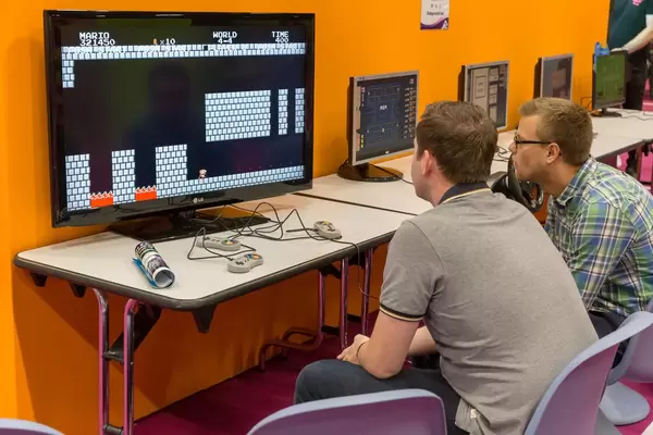 Besucher spielen Super Mario World auf der Super Nintendo SNES Konsole