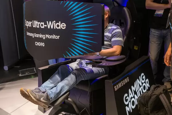 Besucher spielt ein Spiel auf dem Super Ultra-Wide Gaming-Monitor Samsung CHG90