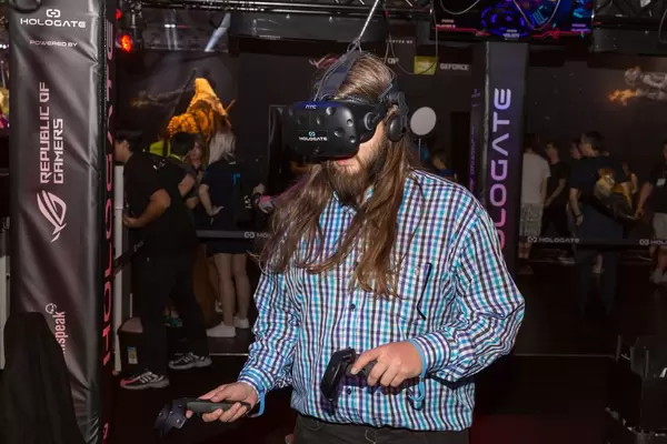 Besucher spielt Hologate mit HTC Vive VR Headset und Controllern