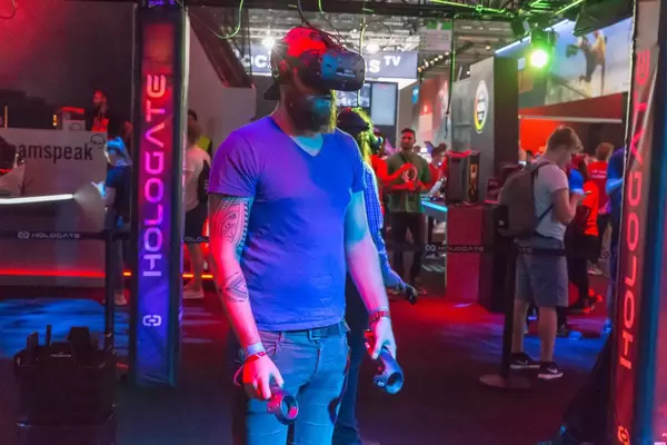 Besucher spielt Hologate mit VR Headset und Controllern von HTC