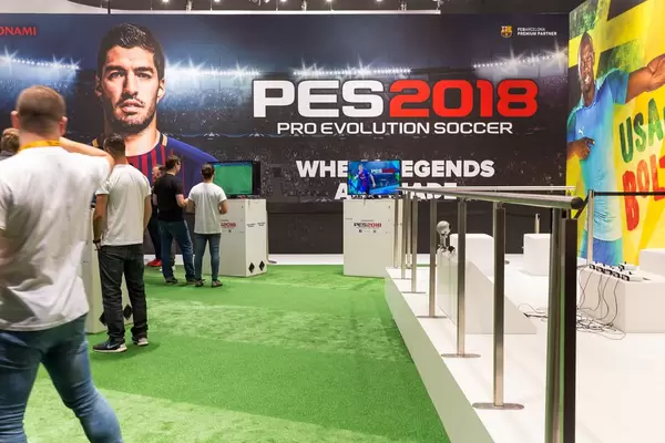 Besucher und PES2018 Plakat im Hintergrund - Gamescom 2017, Köln