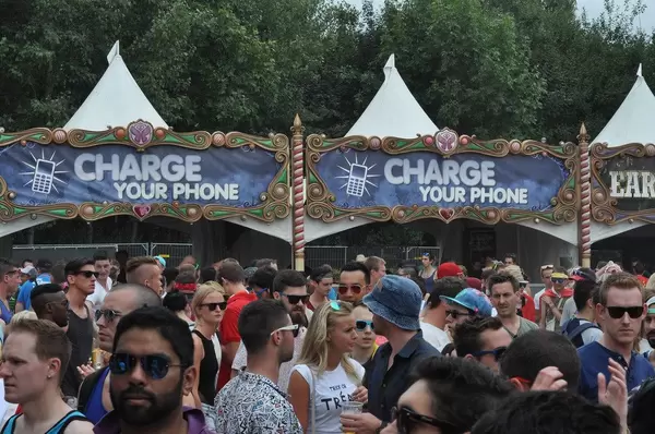 Besucher vor den Ständen mit Handy-Ladestationen - Musikfestival Tomorrowland 2014