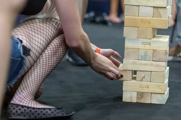 Besucherin löst Blöcke aus dem Jenga-Turm am Caseking-Stand
