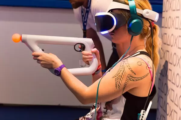 Besucherin verwendet den PlayStation VR aim Kontroller - Gamescom 2017, Köln