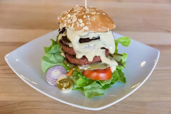 Beyond Meat burger with Portobello mushroom bacon and fresh vegetables on the wooden table of Bunte Burger Cologne