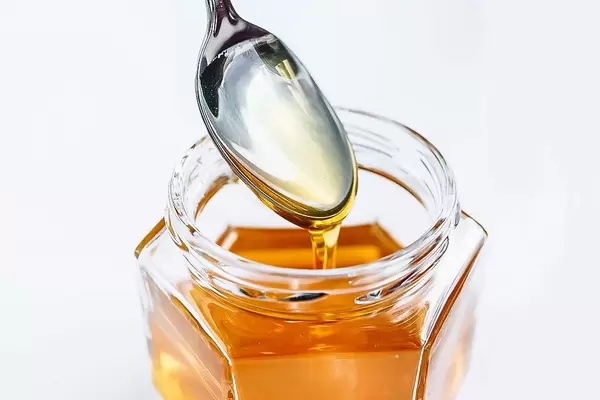 Bienennektar als süßer, flüssiger Brotaufstrich im Glas