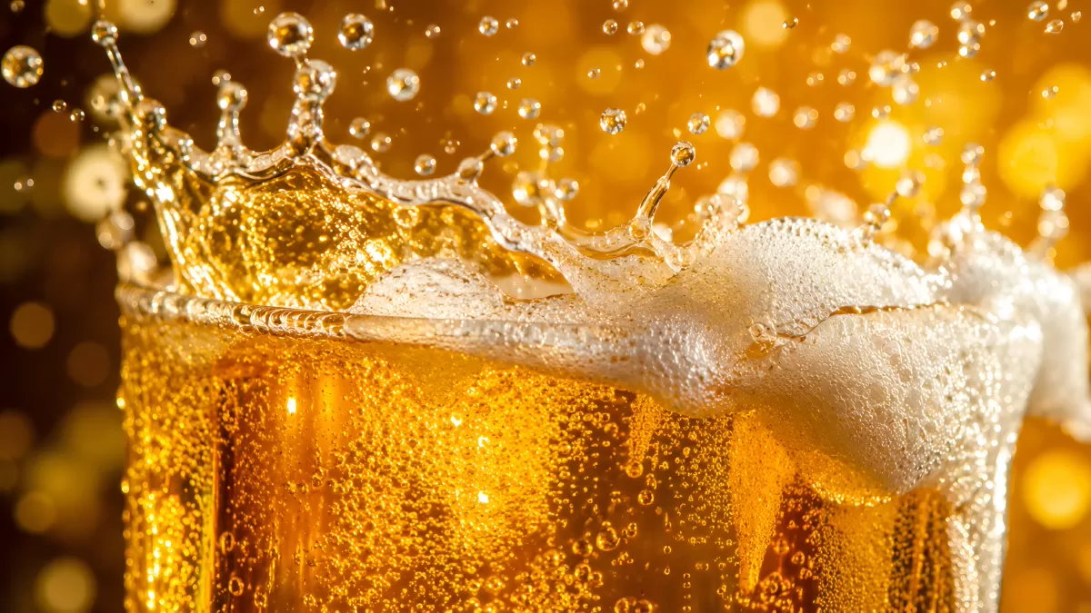 Bierglas mit spritzender Schaumkrone in Nahaufnahme
