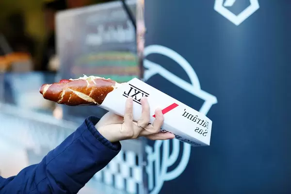 Big German hot dog in woman's hand, Sibiu Christmas market (Flip 2019)