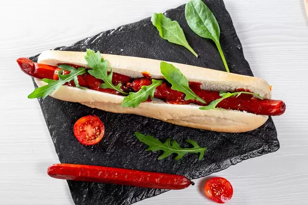 Big hot dog with smoke sausage and fresh tomato