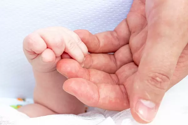 Big man's hand and little hand newborn