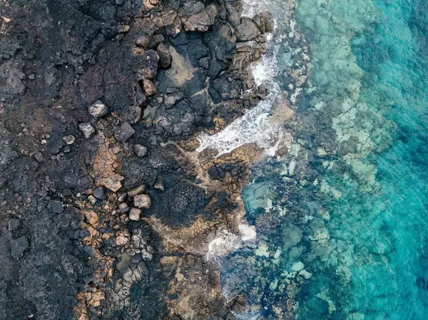 Bird eye view of ocean waves breaking of rocky shore / Vogelperspektive von den Ozeanwellen, die vom felsigen Ufer brechen