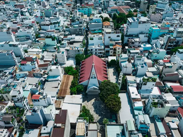 Bird View Drone Photo of a local Catholic Church within a Residential Area with many Houses and Alleys in Ho Chi Minh City, Vietnam