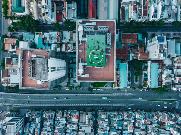 Bird View Drone Photo of Helicopter Landing on a Tall Building next to a busy Street in District 4 in Ho Chi Minh City, Vietnam