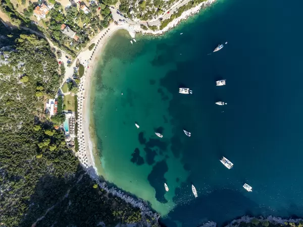 Bird's eye view: Limnonari bay with pine-covered hills, boats and beach on Skopelos