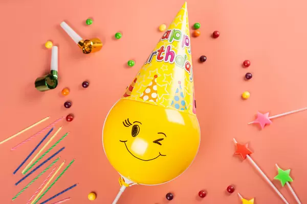 Birthday celebration concept, candles, candies and balloon in cone hat