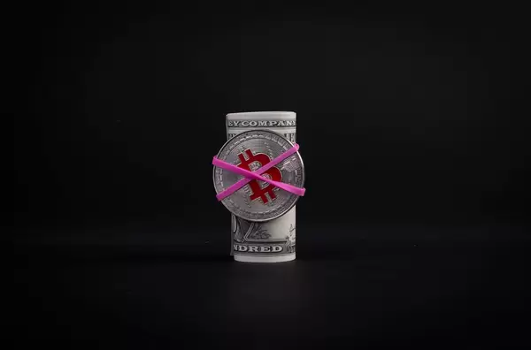 Bitcoin attached at moneyroll on black background