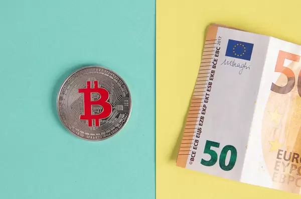 Bitcoin coin and folded 50 Euro banknote