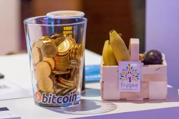 Bitcoin-Münzen am Messestand des Berliner und Münchener frugee Lieferservice für Obst und Gemüse