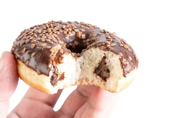 Biten Chocolate Donut with Chocolate Cream in the hand