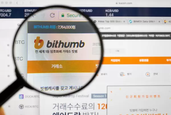 Bithumb-Logo am PC-Monitor, durch eine Lupe fotografiert