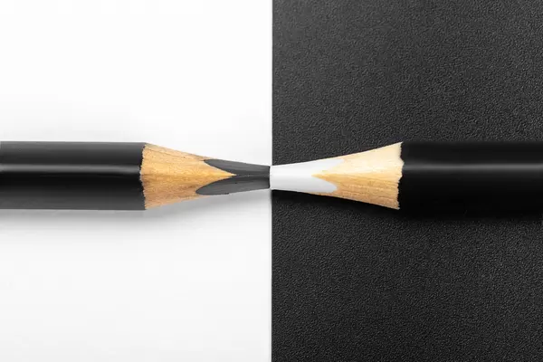 Black and white background with black and white pencils, close up