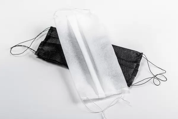 Black and white medical masks on a white background. The concept of individual protection