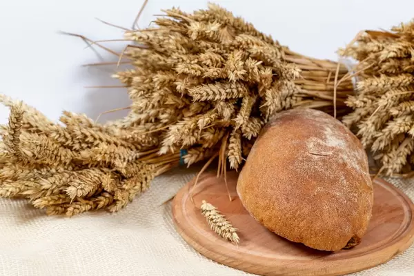 Black bread on the kitchen Board with wheat spikelets
