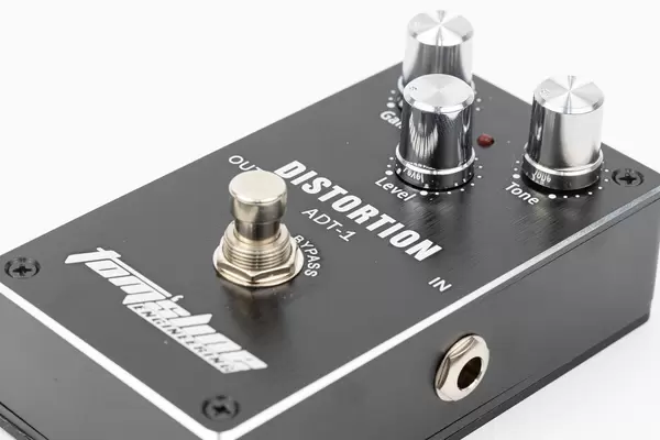 Black Distorzion guitar pedal above white background