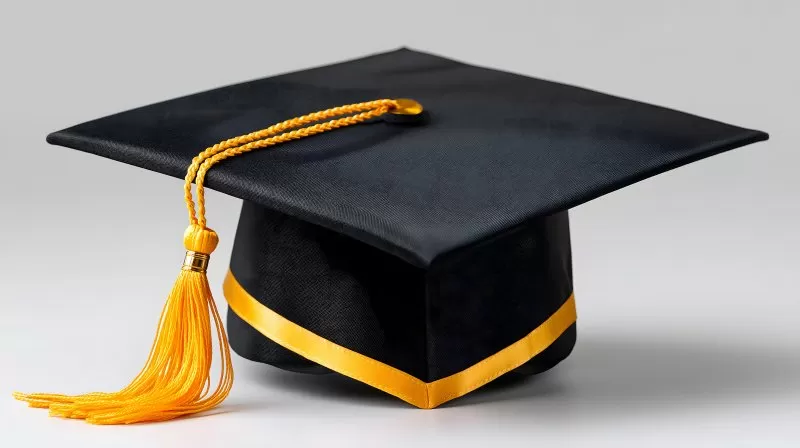 Black graduation cap with golden tassel isolated on white background