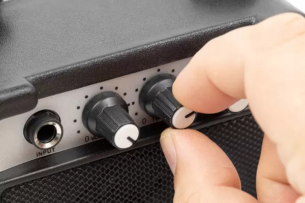 Black Guitar amplifier with hand moving knobs
