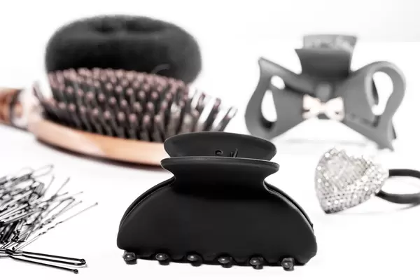 Black hair clips and hair bands with hairbrush on white background (Flip 2019)