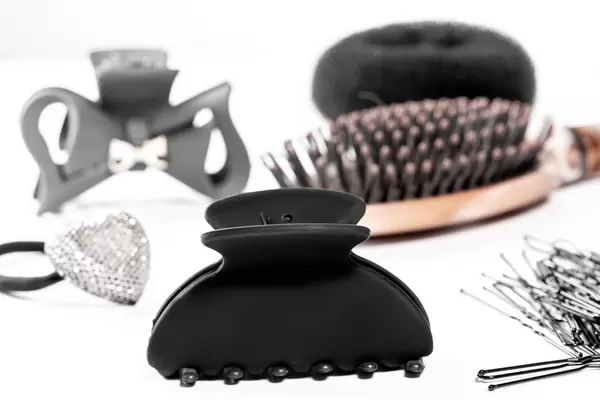 Black hair clips and hair bands with hairbrush on white background