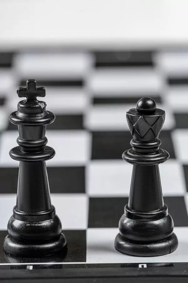 Black king and Queen chess pieces stand on a chessboard (Flip 2019)