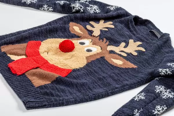 Black knitted baby sweater with a deer pattern on white background (Flip 2019)