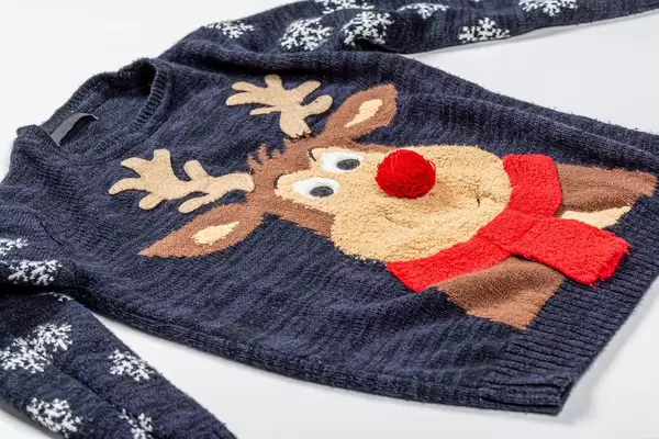 Black knitted baby sweater with a deer pattern on white background