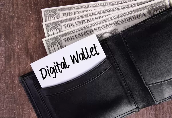 Black leather wallet with Dollar banknotes and note with Digital Wallet text