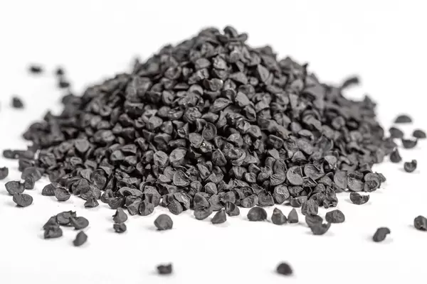 Black onion seeds on a white background, close-up