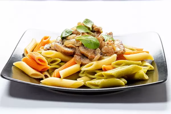 Black plate with colorful pasta with meat and mushrooms (Flip 2019)
