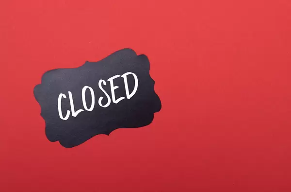 Black sticker with Closed text on red background