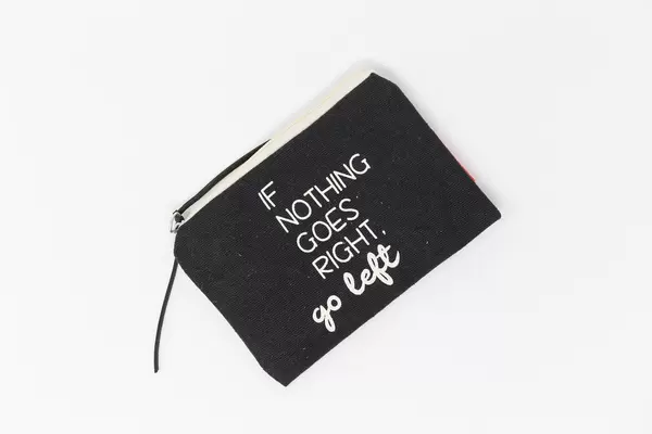 Black toiletries bag  on white background with "If nothing goes right, go left" written in white